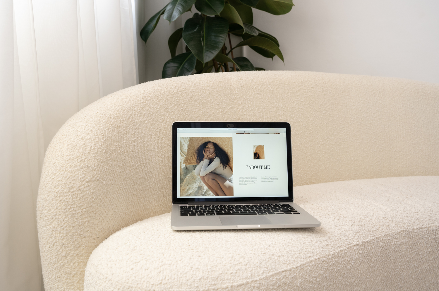 Laptop sitting on a cream couch with a website displayed