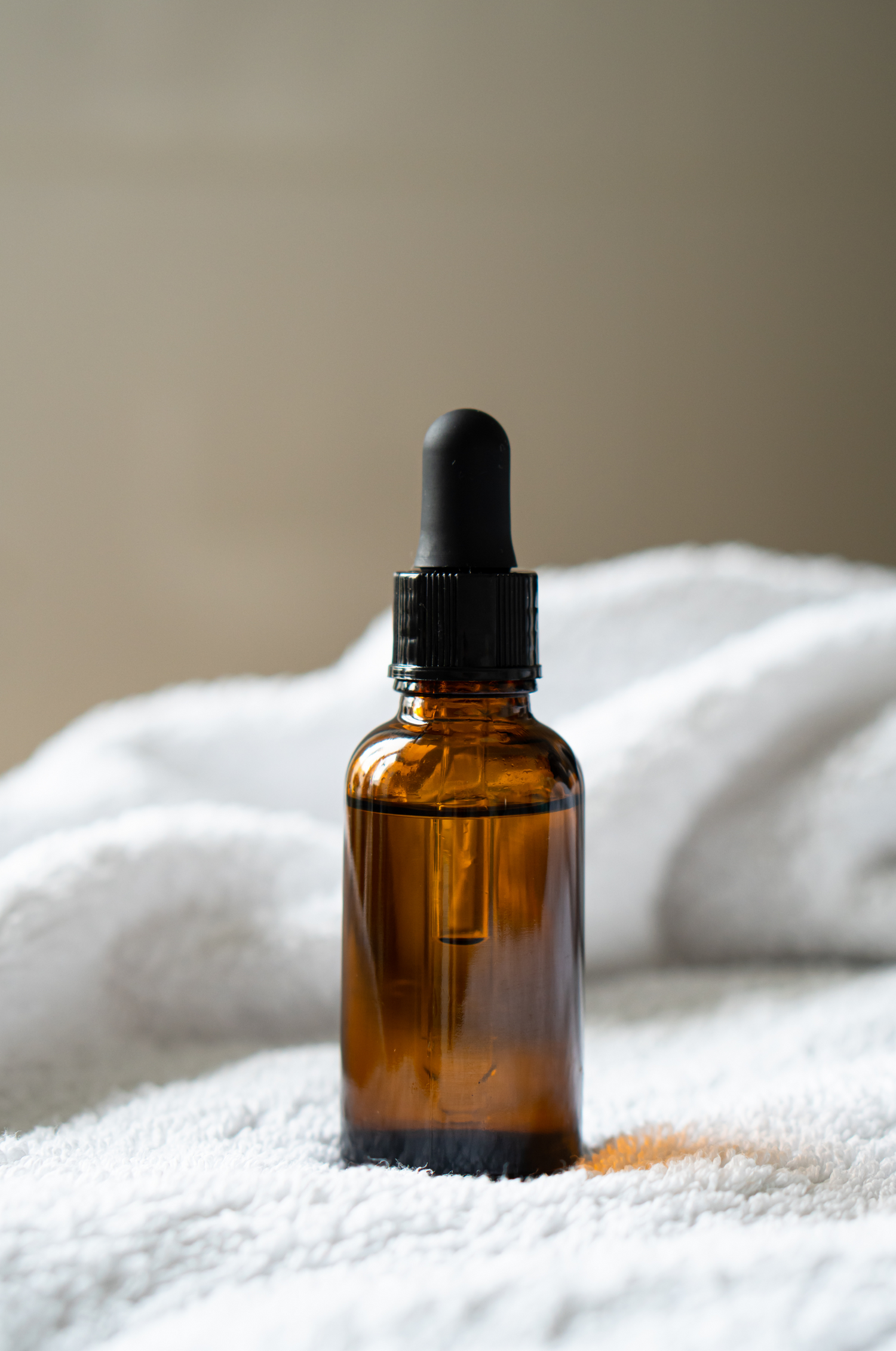 Amber dropper bottle on a white towel
