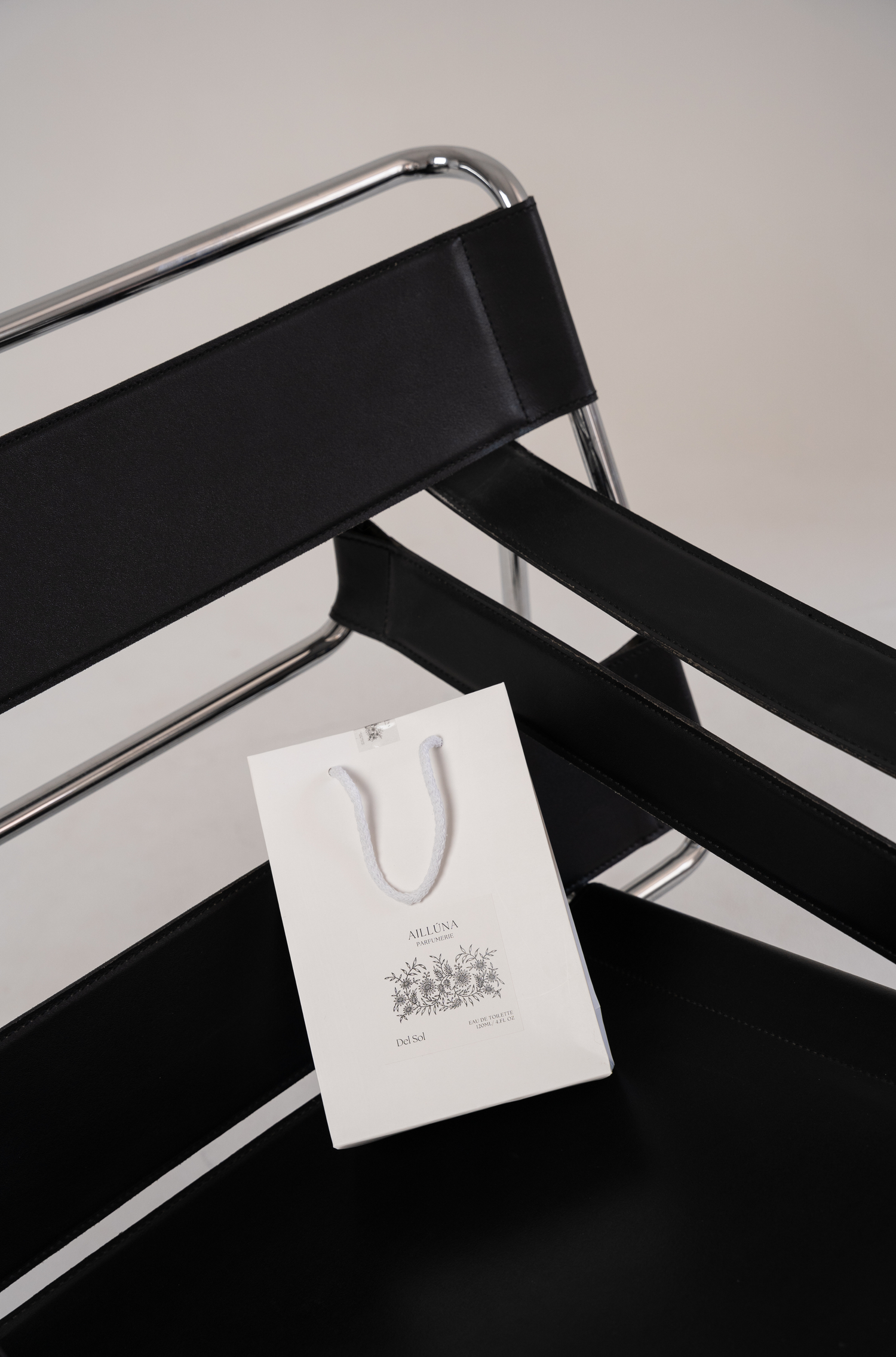 Black metal chair with a branded bag sitting on it