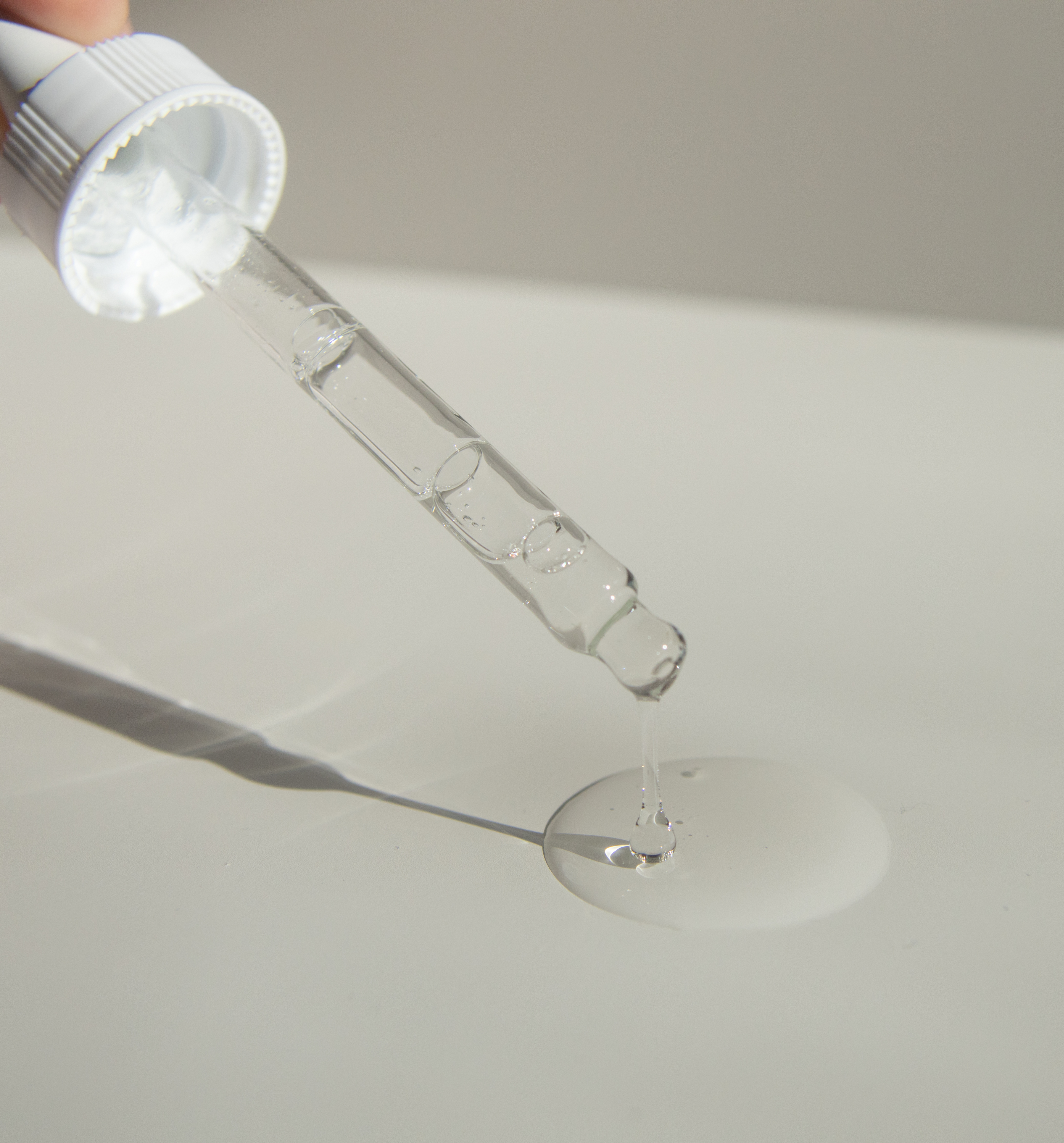 Serum dropper dispensing serum onto a neutral surface