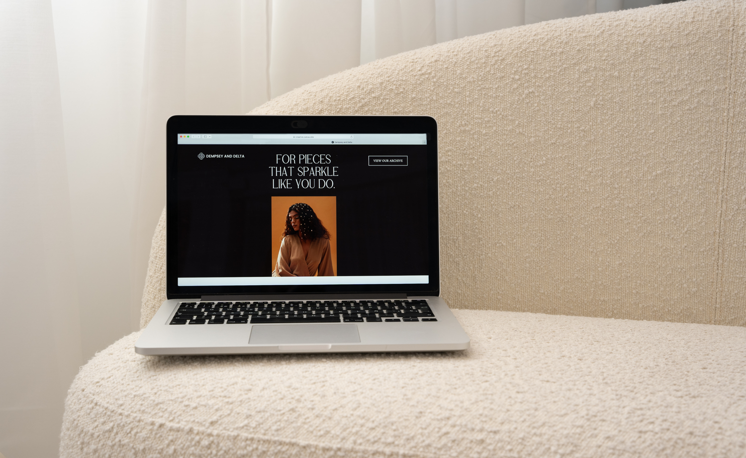 Laptop sitting on a cream couch with a website page displayed