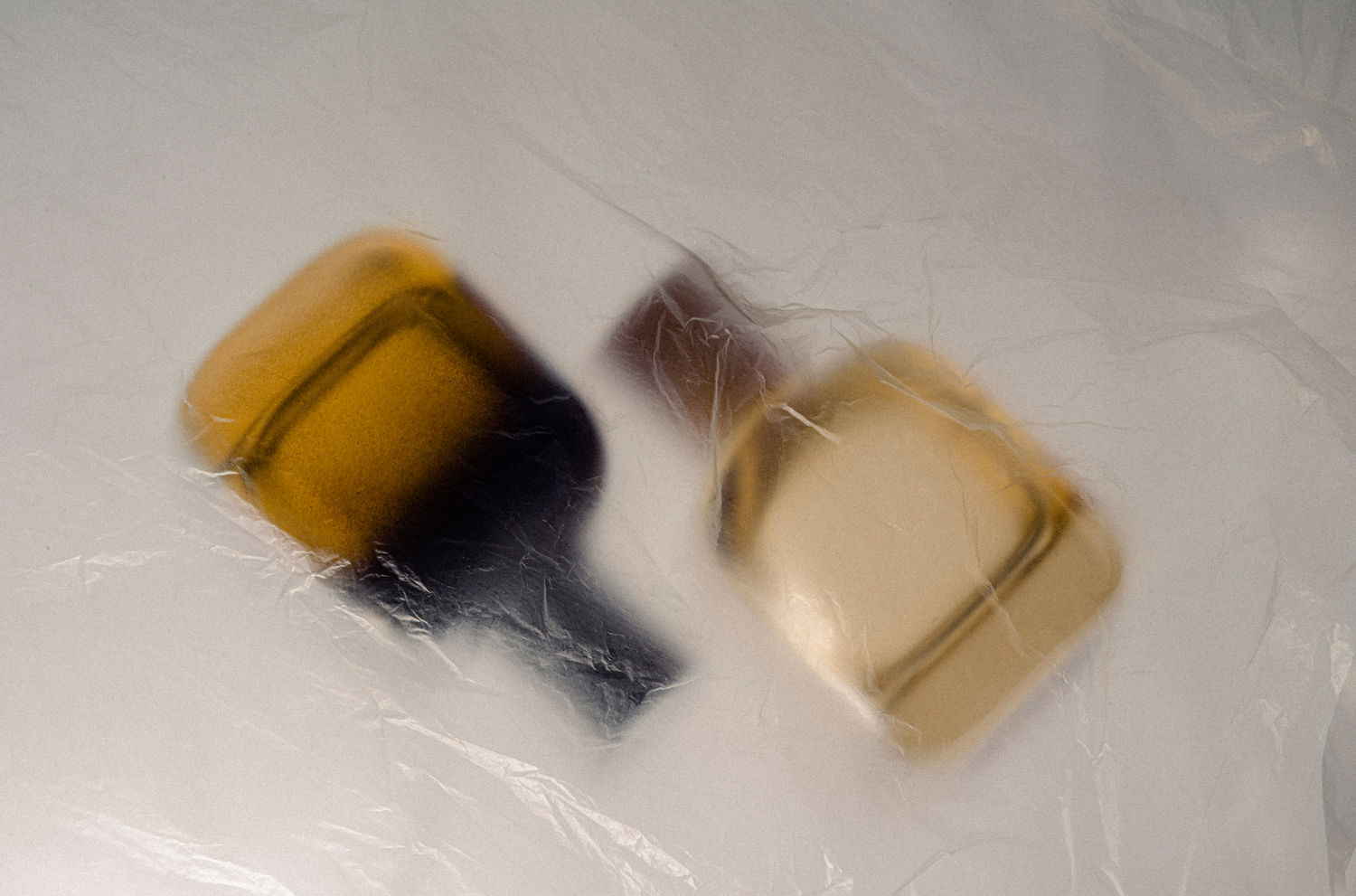 Two product bottles covered by a clear plastic bag
