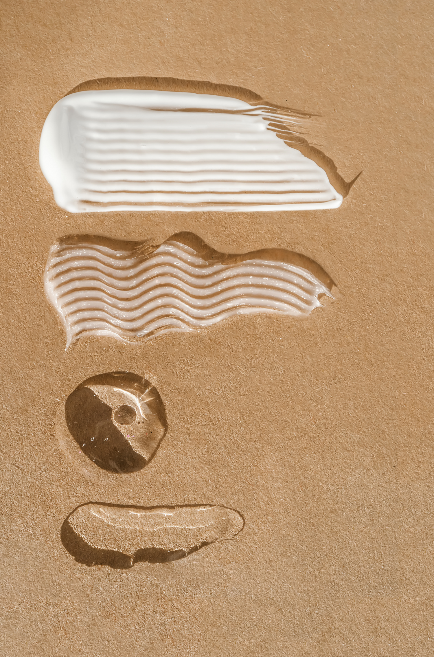 Four product texture swipes on a textured terracotta background